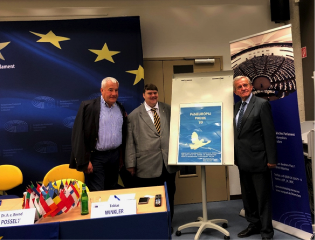 Das Bild zeigt v.l.n.r.: Dr. Ludwig Spaenle, Bernd Posselt und Szabolcz Fazakas am Ende der Veranstaltung vor einem Originalplakat des Paneuropäischen Picknicks.